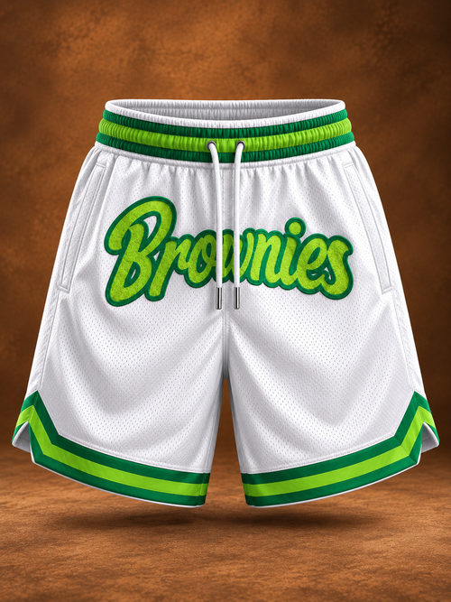 White basketball shorts with green and lime green trim, featuring the word 'Brownies' in green script across the front, shown against a brown textured background.